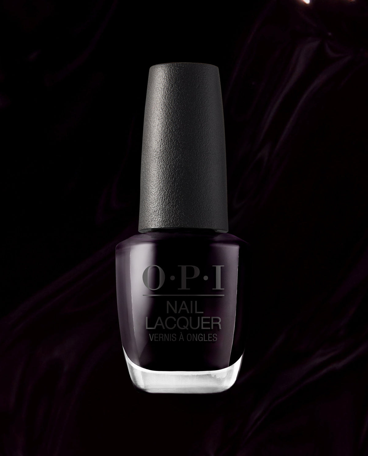 OPI Lincoln Park After Dark nail lacquer bottle displays a deep black-purple polish with a textured black cap against a dark satin background, a dramatic choice for fall nail colors.