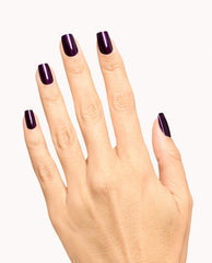 Hand displaying glossy deep plum OPI Lincoln Park at Midnight gel nail polish, a dark purple manicure shade ideal for fall nail colors on a clean white background.
