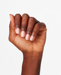 Hand with neatly manicured nails shows Machu Peach-u OPI nail polish, a soft peachy nude nail lacquer with a glossy finish, against a clean white background for a minimalist beauty product shot.
