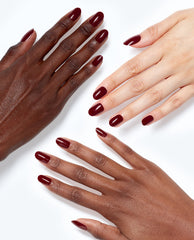 Hands with glossy deep burgundy OPI Malaga Wine xPRESS/ON press-on nails display rich fall nail colors on multiple skin tones against a white background.