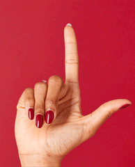Hand with glossy deep wine red nails shows OPI Malaga Wine nail lacquer, a rich shade for fall nail colors, against a matching red background.