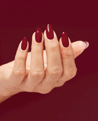 Hand displays glossy almond nails painted deep wine red with OPI Infinite Shine Malaga Wine, a rich shade for fall nail colors, against a matching burgundy background.