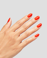 Hand with neatly manicured oval nails painted in bright red Mini Plaid Flirt Infinite Shine OPI nail polish, shown against a light gray background to highlight the glossy, chip-resistant color payoff.