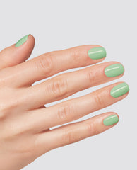 Hand modeling glossy mint green OPI Mint to Be at-home gel nail polish on short rounded nails against a light gray studio background.