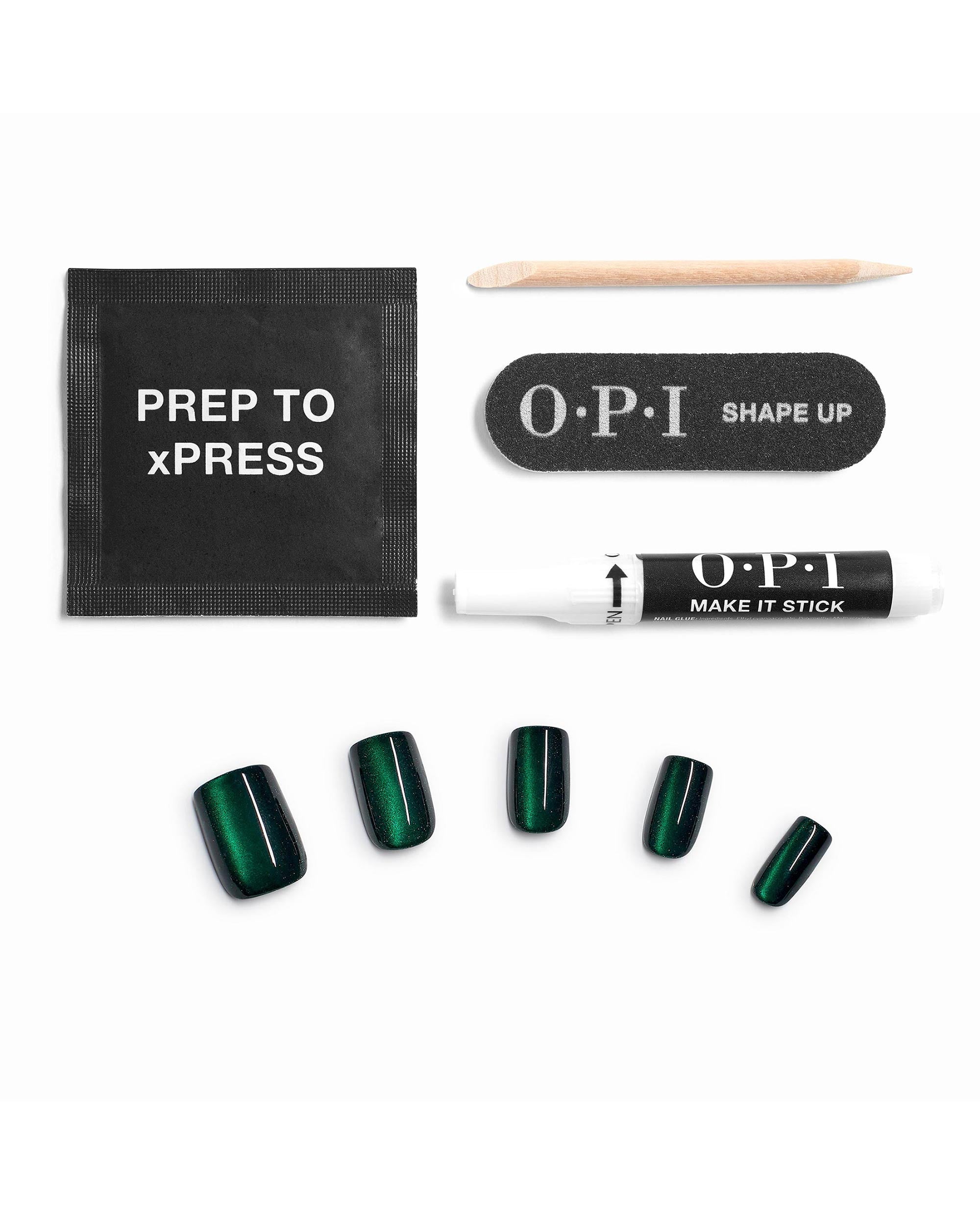 Model for Daze xPRESS/ON Effects press-on nails showcasing deep emerald green nail polish with cat-eye shimmer, arranged with OPI Prep to xPRESS wipe, cuticle stick, Shape Up mini file, and Make It Stick adhesive on white—fresh spring nail colors.