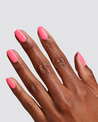 Hand with neatly manicured nails shows bright bubblegum pink MVPink at-home gel nail polish, resembling an OPI shade, against a plain gray background, ideal for a modern nail polish gift set look.