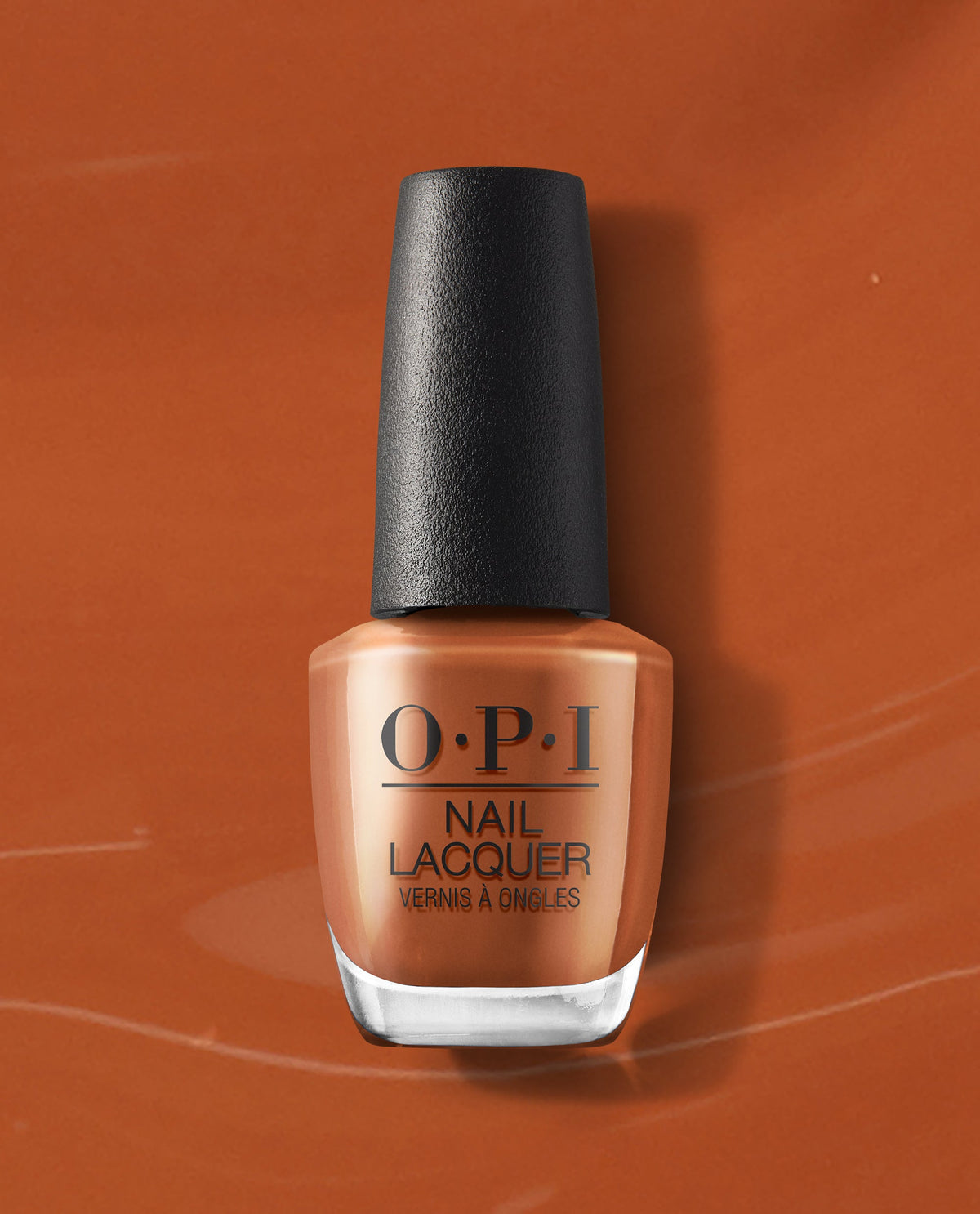 OPI nail polish bottle, shade My Italian is a Little Rusty, standing upright against a matching warm rusty orange background, showing the creamy burnt-orange nail lacquer color in a clear glass bottle with black cap.