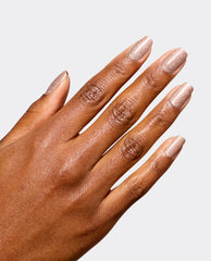 Hand modeling OPI Infinite Shine My Private Yacht, a sparkling champagne taupe manicure with glossy shimmer, shown on medium-brown skin against a light gray background for fall nail colors.