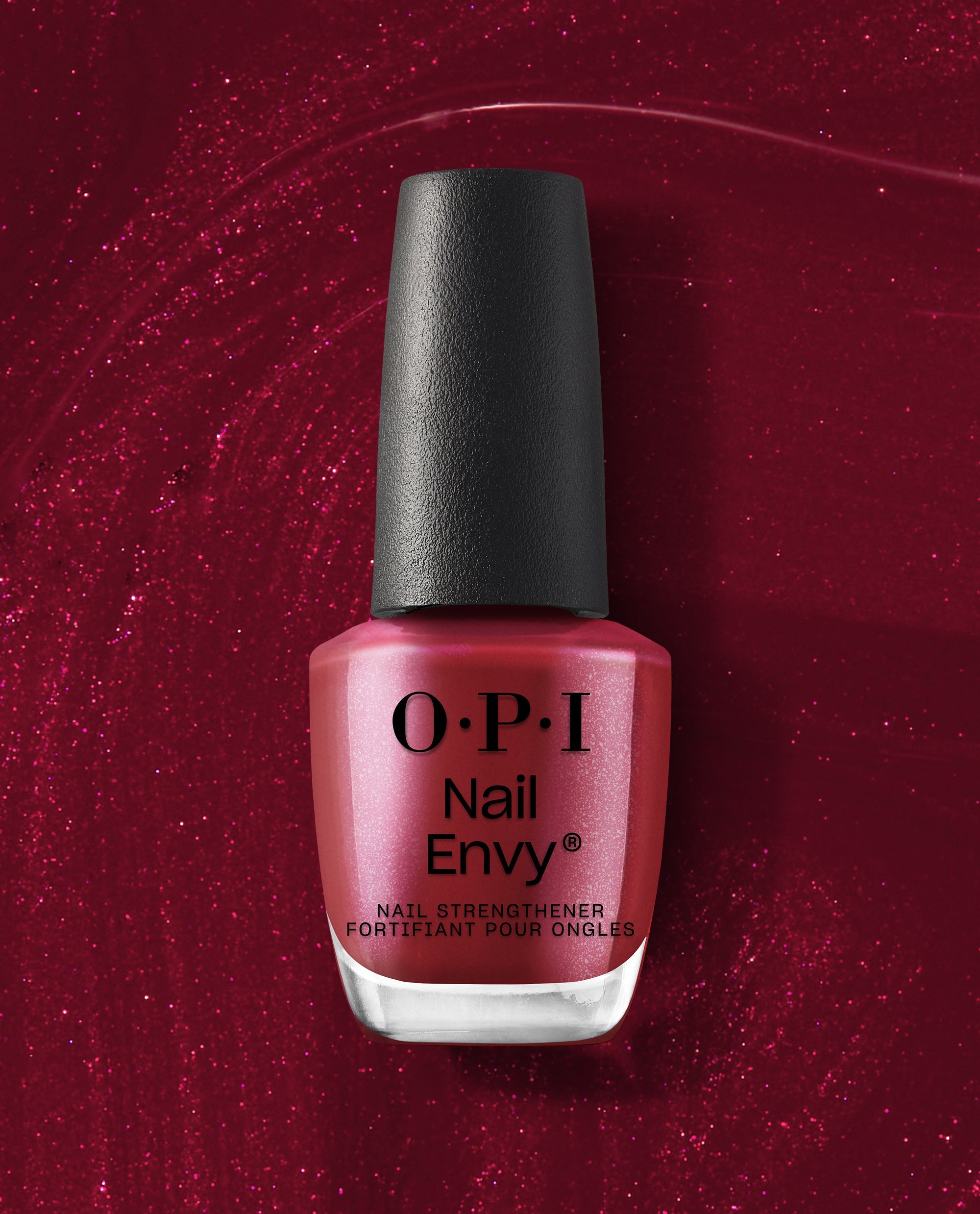 OPI Nail Envy Tough Luv Nail Strengthener bottle stands upright with a black cap and shimmery berry-red formula against a sparkling deep red backdrop, ideal for fall nail colors.