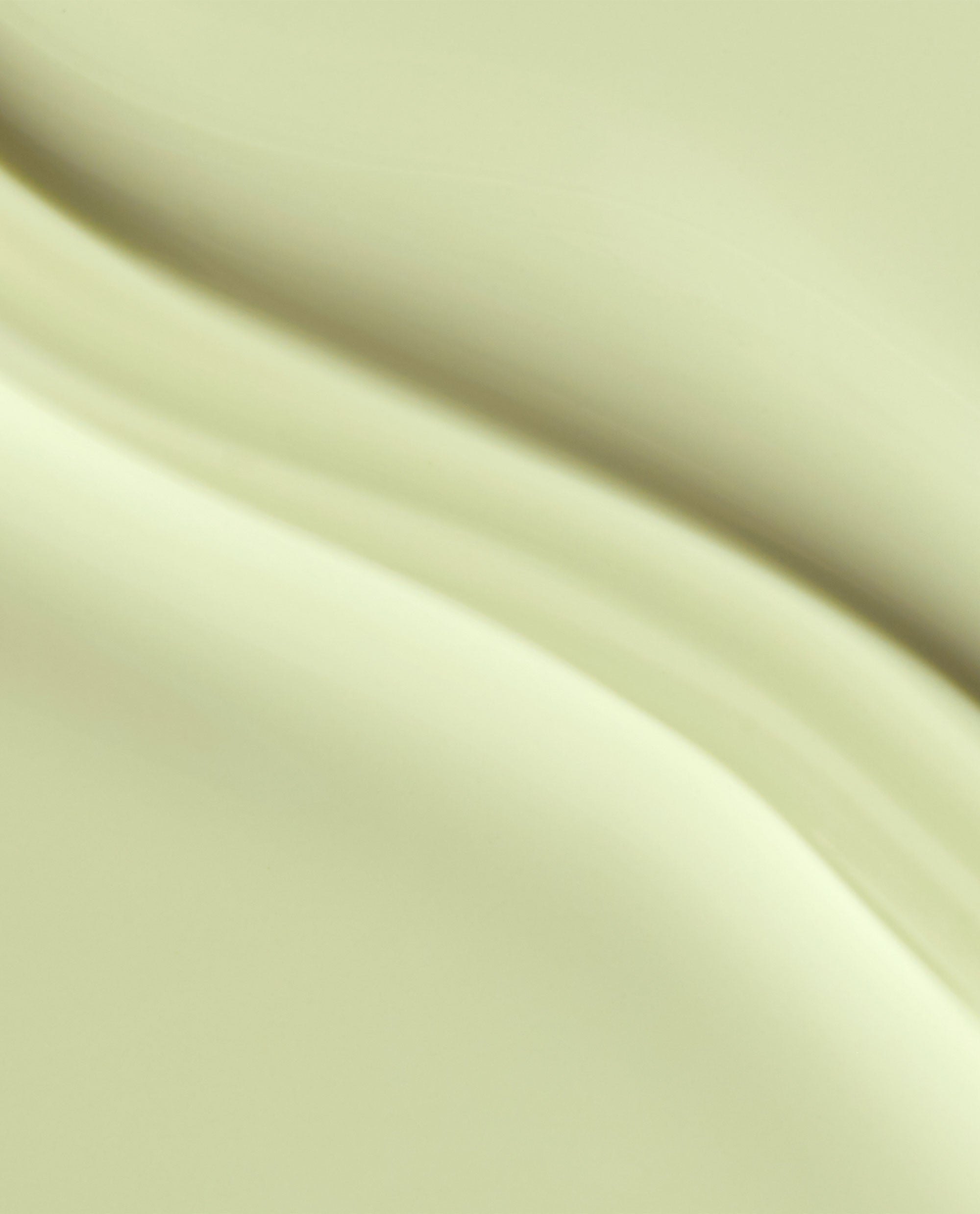 OPI Oh Baby! Infinite Shine nail polish swatch shows a glossy pale butter-yellow creme shade with soft curved brush strokes in a close-up texture.