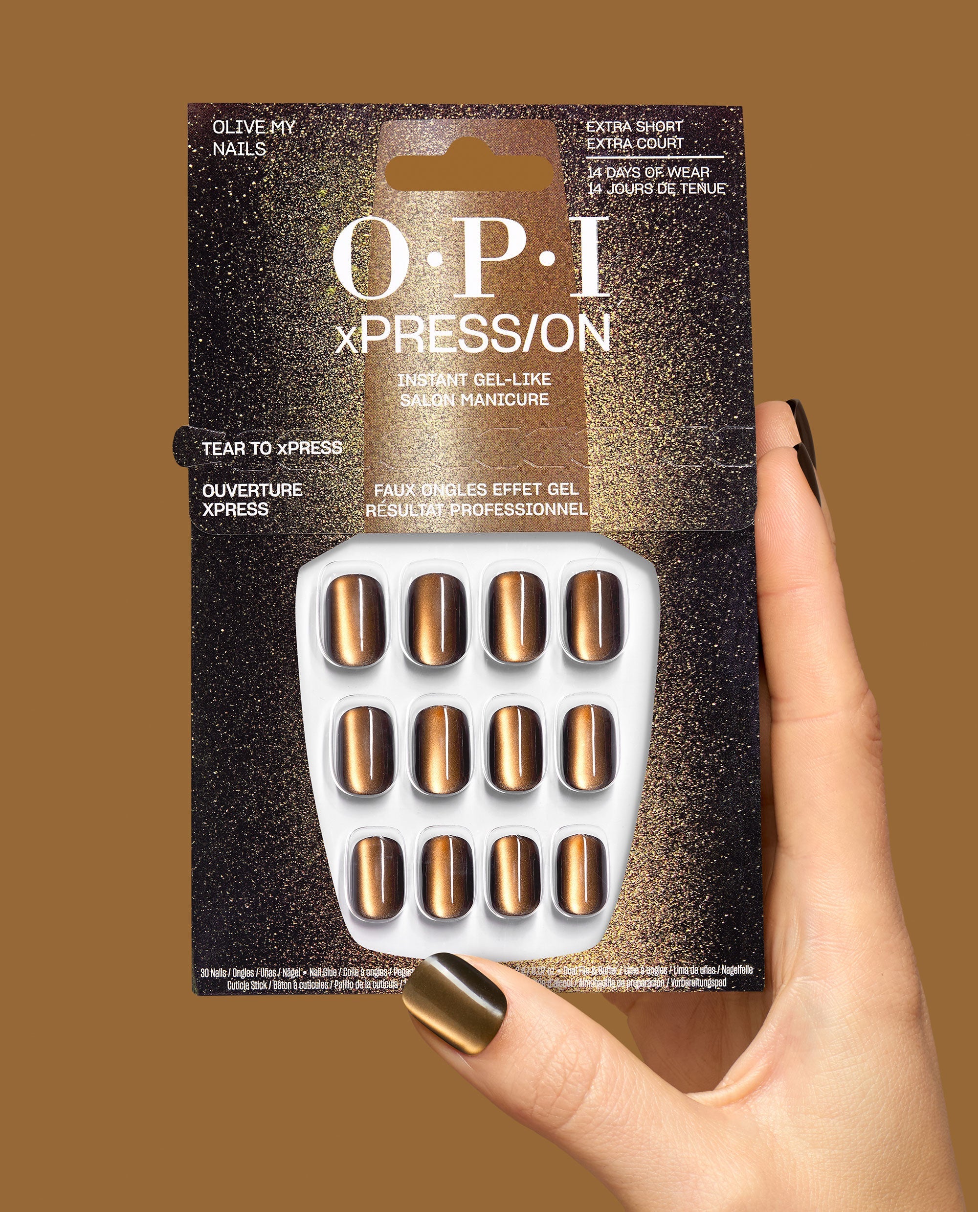 Hand holding OPI xPRESS/ON Olive My Nails extra short press-on nails in metallic bronze, showcasing gel-like fall nail colors in retail packaging.