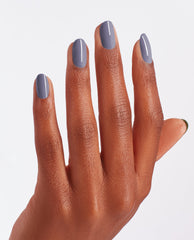 Hand with medium brown skin tone showing four fingers painted in OPI ❤️ DTLA, a glossy slate gray OPI nail polish, against a clean white background to highlight the smooth, even nail lacquer coverage.