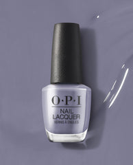 OPI ❤️ DTLA OPI nail polish bottle standing upright, showcasing a creamy muted lavender-gray nail lacquer shade against a matching glossy painted background, highlighting the modern, city-inspired color for manicures and pedicures.