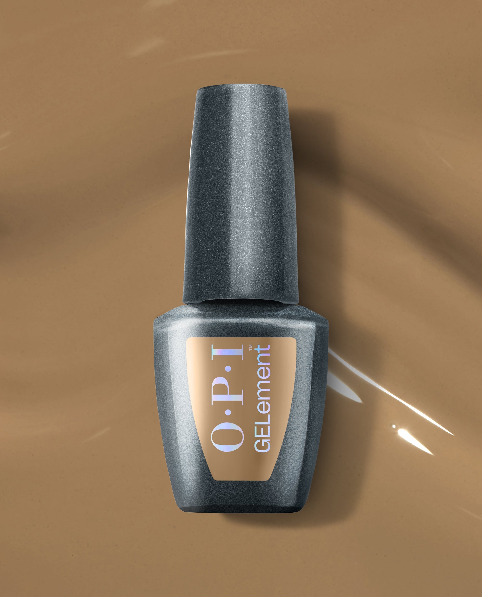 OPI GELelement+ Peanut Butter & Gel-ly at-home gel nail polish bottle rests on glossy peanut-butter brown polish, showcasing a warm neutral shade for fall nail colors.