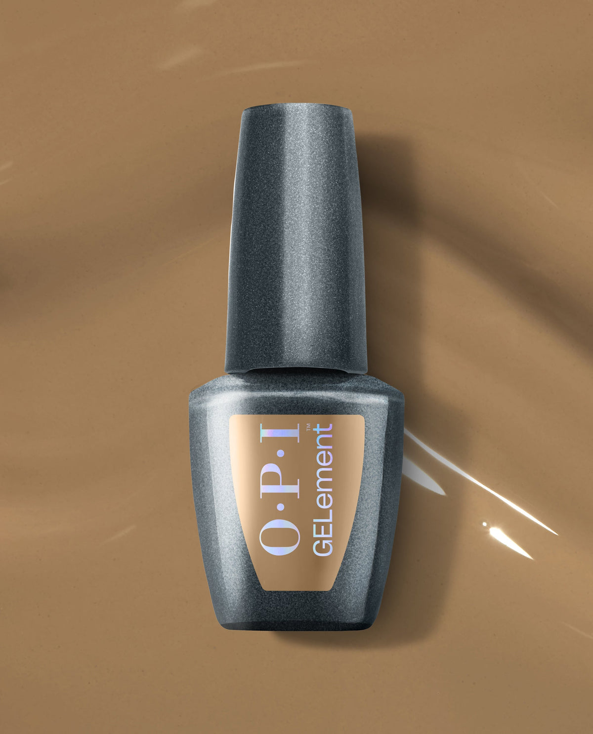 OPI GELelement+ Peanut Butter & Gel-ly at-home gel nail polish bottle rests on glossy peanut-butter brown polish, showcasing a warm neutral shade for fall nail colors.