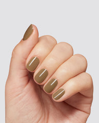 Hand displays glossy taupe-brown Peanut Butter & Gel-ly at-home gel nail polish by OPI on short rounded nails, a warm fall nail color against a light gray studio background.