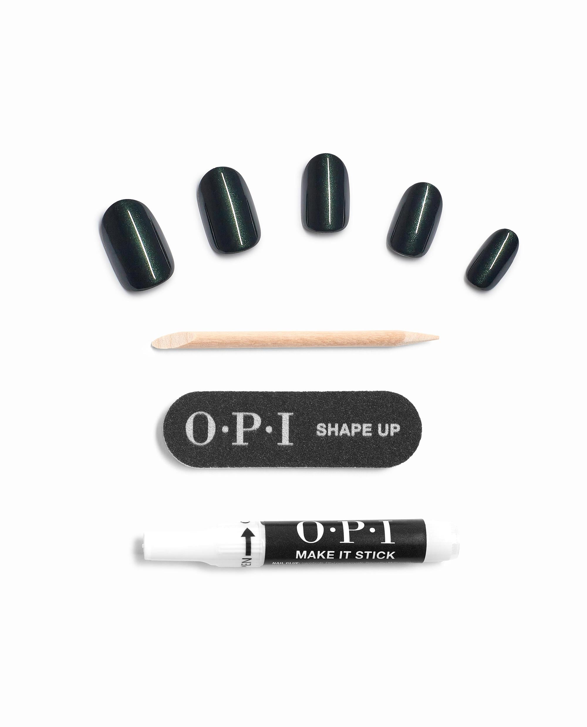 Peppermint Bark and Bite On Point press-on nails, five glossy deep green tips fanned out with a wooden cuticle stick, OPI Shape Up mini file, and Make It Stick prep pen on white—delivering a chic green nail polish vibe for spring nail colors by OPI.