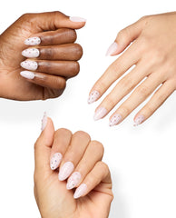 OPI Princess Treatment Sticking Point accents decorate pale pink almond manicures with tiny multicolor rhinestones on diverse hands against a white background, a soft choice for fall nail colors.