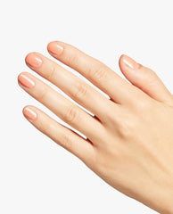 Hand displaying a glossy peach shimmer manicure with Queens Rule Nail Lacquer, an OPI trending nail polish shade, on short rounded nails against a clean white background.