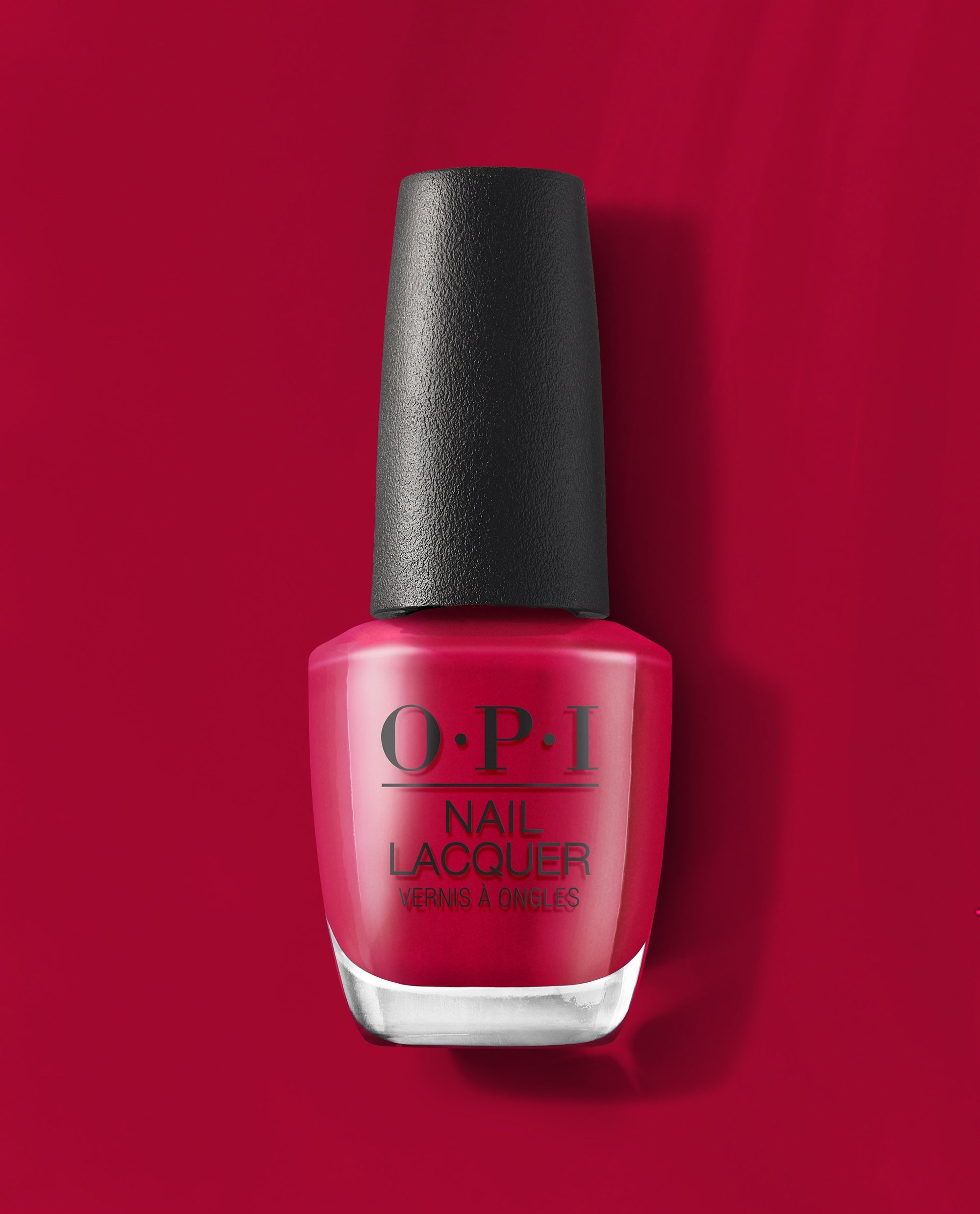 OPI nail polish bottle in Red-Veal Your Truth, a bold deep red nail lacquer, standing upright on a matching red background, highlighting the glossy finish and sleek black cap for a modern manicure look.