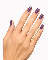 Hand displays a glossy deep purple manicure with OPI Reign or Shine Infinite Shine polish, a rich shade for fall nail colors, on a clean white background.