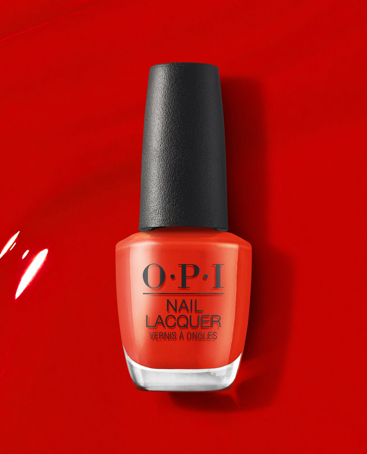 OPI nail polish bottle of Rust & Relaxation nail lacquer standing upright, showcasing its warm rust-orange shade with a black cap against a glossy red painted background, highlighting the rich, salon-quality color for manicures and pedicures.