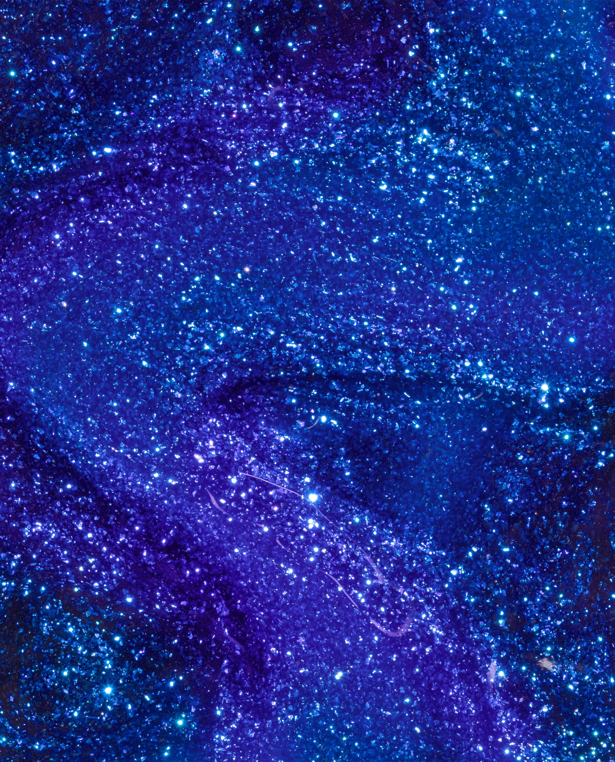 Scorpio Seduction OPI nail polish nail lacquer swatch swirling in a deep indigo and cobalt blue base packed with fine glitter, creating a shimmering galaxy-like finish across the glossy liquid surface.