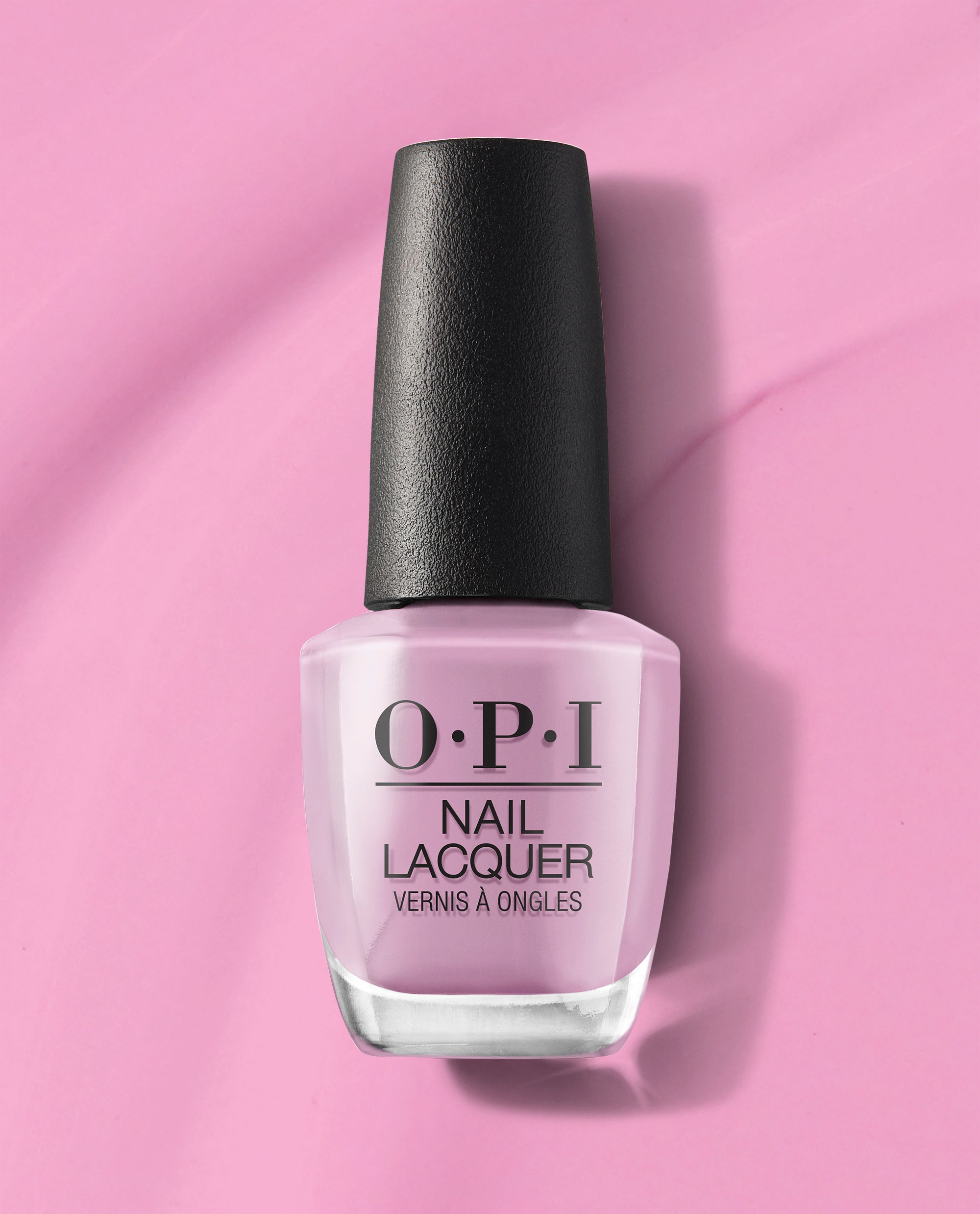 Seven Wonders of OPI nail lacquer bottle filled with soft pastel pink OPI nail polish, standing upright with a black textured cap on a matching pink background, showcasing the classic OPI branding for a salon-quality manicure look.