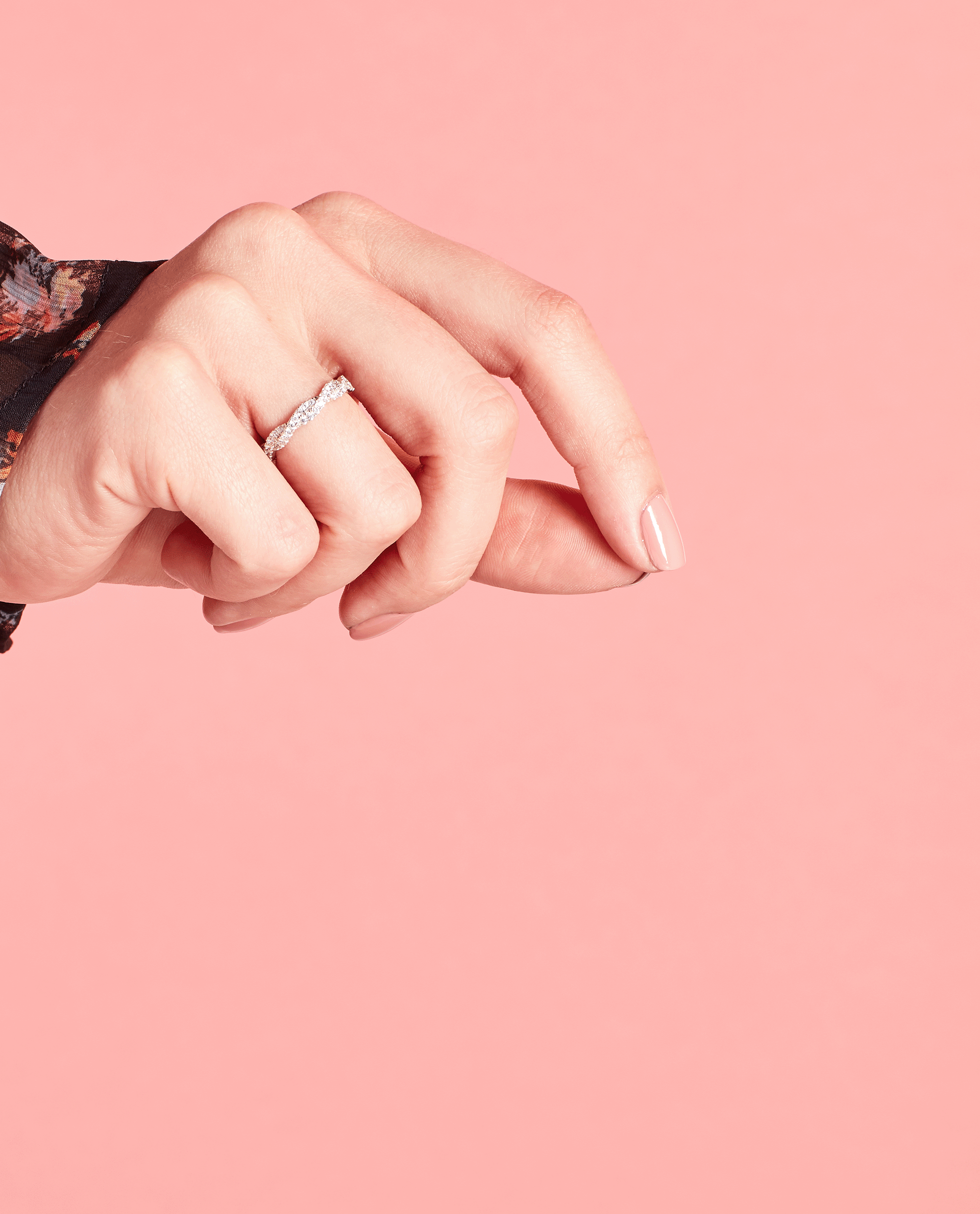 Hand with neatly manicured nails painted in OPI nail polish shade Somewhere Over the Rainbow Mountains softly posed against a solid pink background, showcasing the glossy neutral nail lacquer on short, rounded nails.