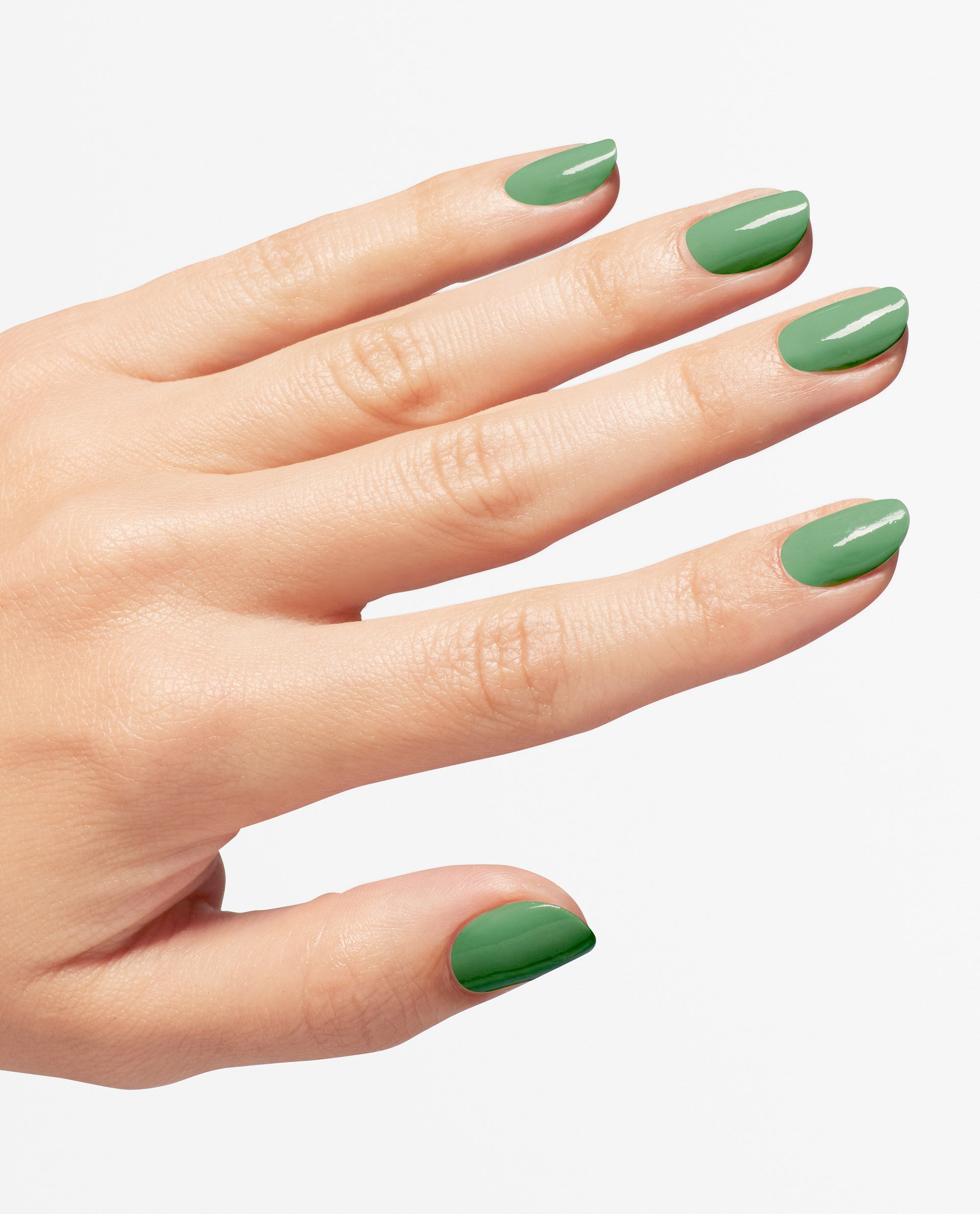 Manicured hand wears OPI $elf Made Nail Lacquer, a glossy green nail polish, showing smooth coverage on short oval nails against a white background, highlighting fresh spring nail colors with a salon-quality shine.