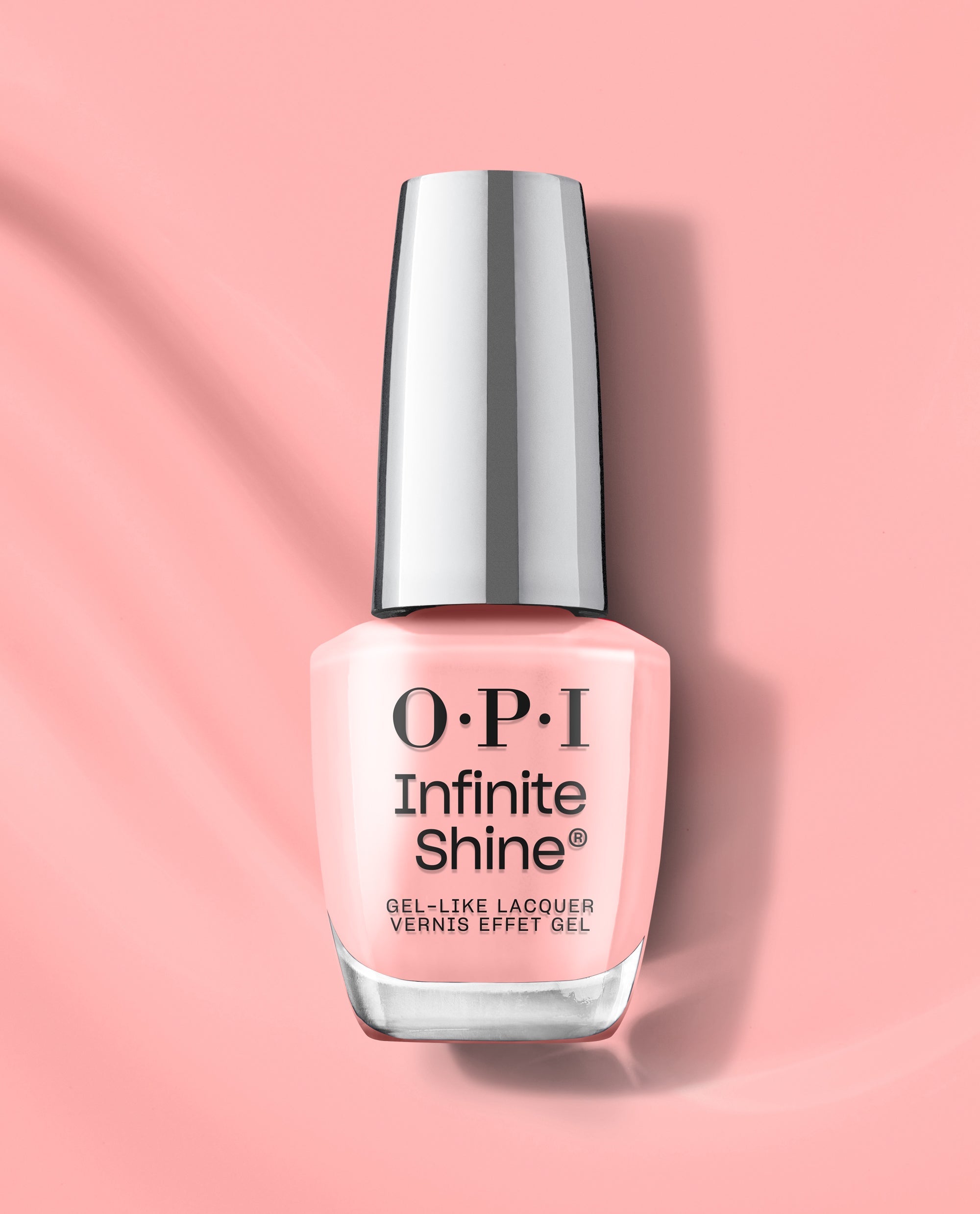 OPI Infinite Shine Still Going Strong gel-like lacquer in a soft blush pink shade stands upright on a matching pink background, ideal for fall nail colors.