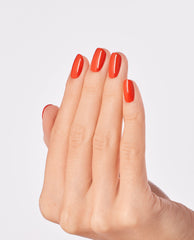 Manicured hand showing glossy, bright orange Suzi Needs a Loch-smith nail lacquer, highlighting the smooth, even coverage and shine of this OPI nail polish against a clean white background.