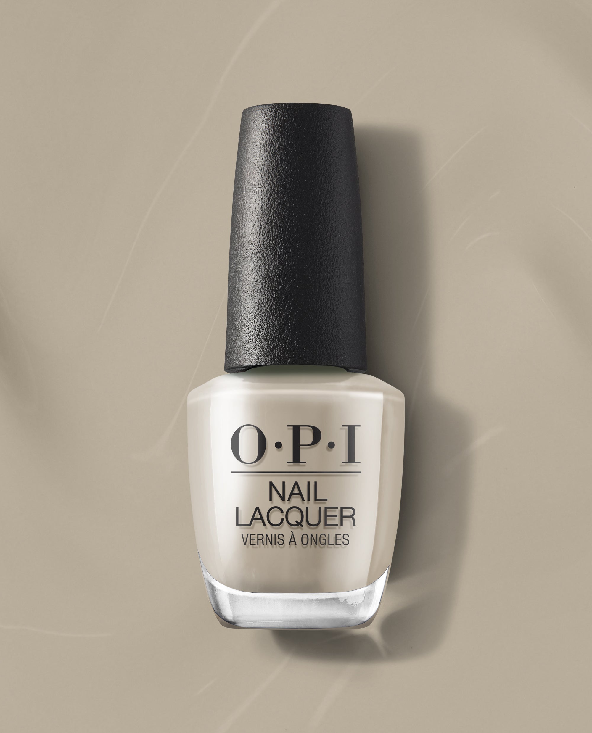 OPI nail polish bottle of Suzi’s Pager nail lacquer in a soft beige cream shade standing upright on a matching neutral beige background, highlighting the glossy finish and black textured cap for a modern, minimalist product look.