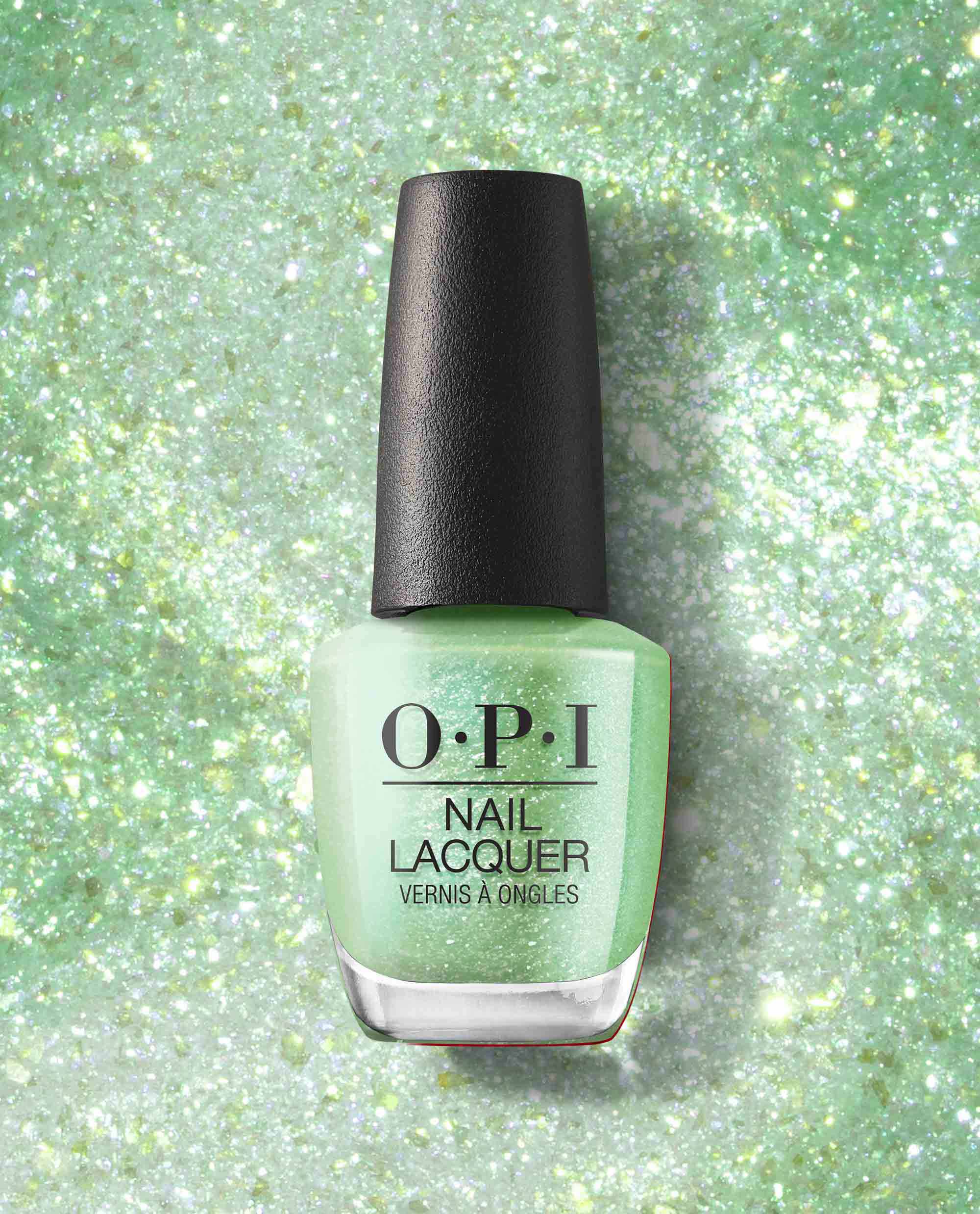 OPI Taurus-t Me Nail Lacquer bottle stands upright, showcasing a mint, glittery green nail polish shade with black logo, set against a matching sparkly backdrop—a fresh pick for spring nail colors from OPI.