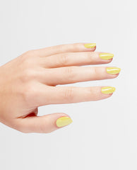 Hand modeling glossy OPI Infinite Shine This Chic is Bananas yellow nail polish on short rounded nails against a clean white studio background.
