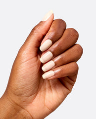 Hand modeling glossy almond-shaped nails in Throw Me a Wink dipping powder, a soft creamy ivory shade from OPI fall nail colors, against a clean light gray background.