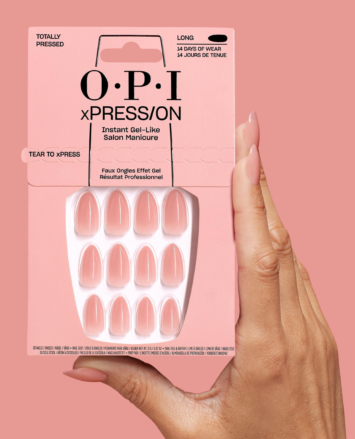 Hand holding OPI Totally Pressed xPRESS/ON Iconic Shades long press-on nails in soft pink, showing the full nail set packaging against a matching blush background, ideal as an OPI nail polish gift set for salon-quality manicures at home.