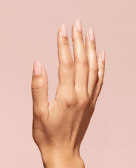 Hand with almond-shaped nails painted a glossy soft-peach shade, showcasing OPI We Canyon Do Better Nature Strong Vegan Nail Lacquer against a matching blush background, ideal hero shot for an OPI nail polish gift set product page.