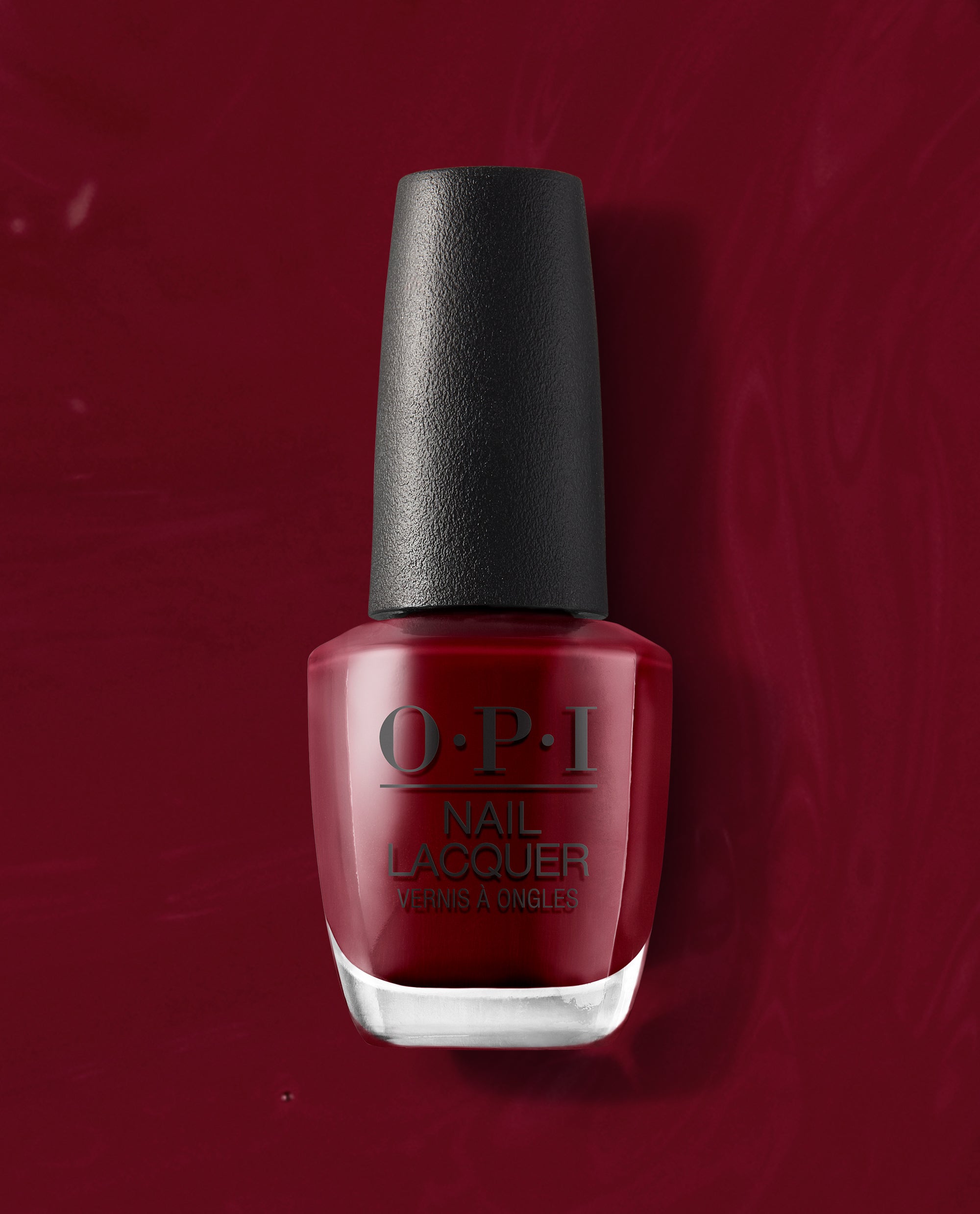 OPI We the Female nail lacquer bottle stands upright, showing a deep red polish shade against a matching glossy red background, ideal for rich fall nail colors.