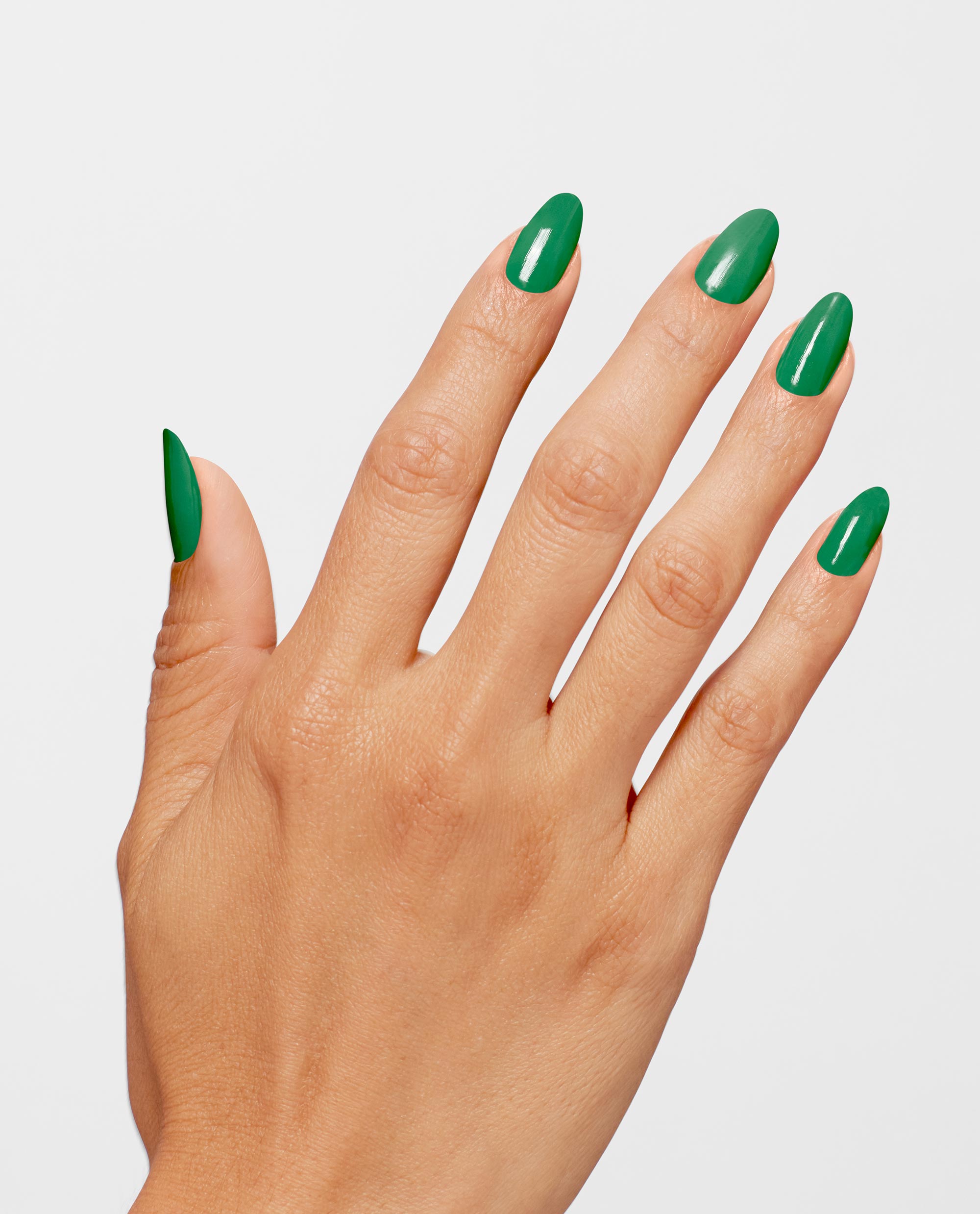 Manicured hand displays glossy emerald nails wearing OPI Infinite Shine Won for the Ages green nail polish, fingers splayed against a clean white background, highlighting rich coverage and long-lasting shine for trending spring nail colors.