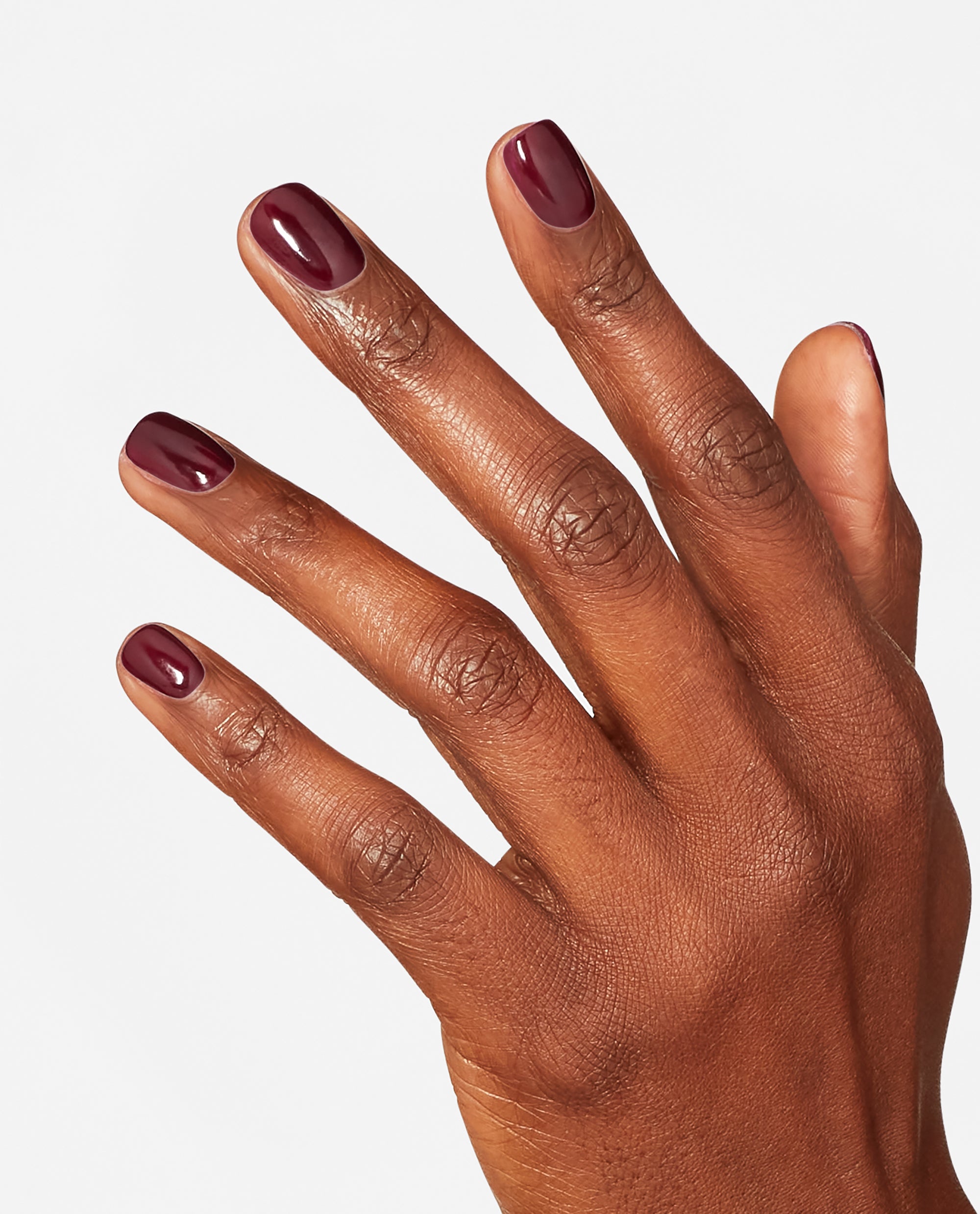 Hand with neatly manicured nails showcases OPI nail polish shade Yes, My Condor Can-do!, a glossy deep plum nail lacquer, against a clean white background highlighting the rich color and smooth finish.