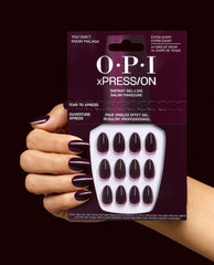 OPI xPRESS/ON You Don’t Know Malaga press-on nails in deep burgundy are shown on a manicured hand holding the matching package, highlighting glossy extra-short fall nail colors.
